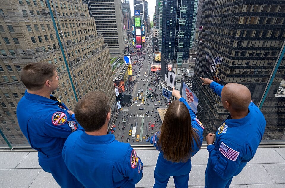 Artemis II astronauts looking across Times Square from the Skywalk glass-sided observation deck