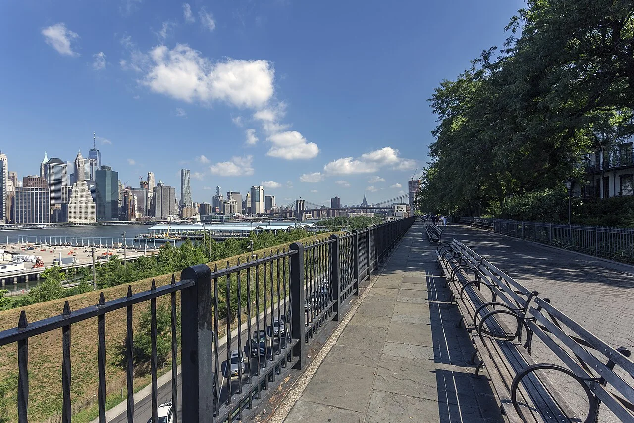 Looking north along Brooklyn Heights Promenade, with benches and the Manhattan skyline across the river