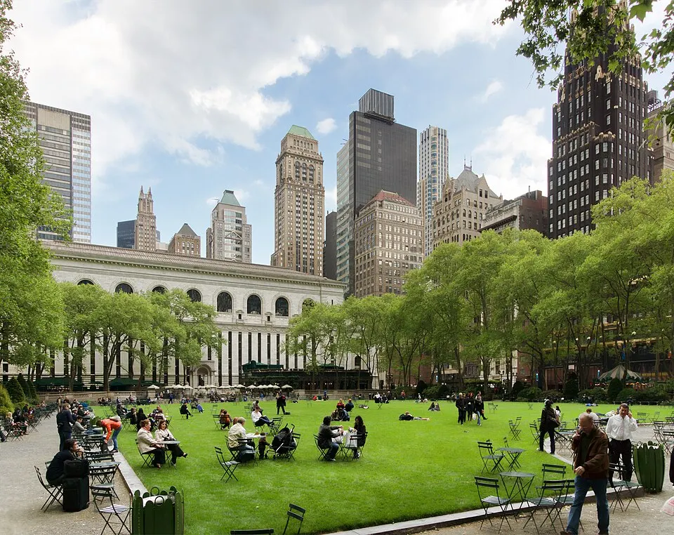 Bryant Park lawn and the New York Public Library surrounded by Midtown towers