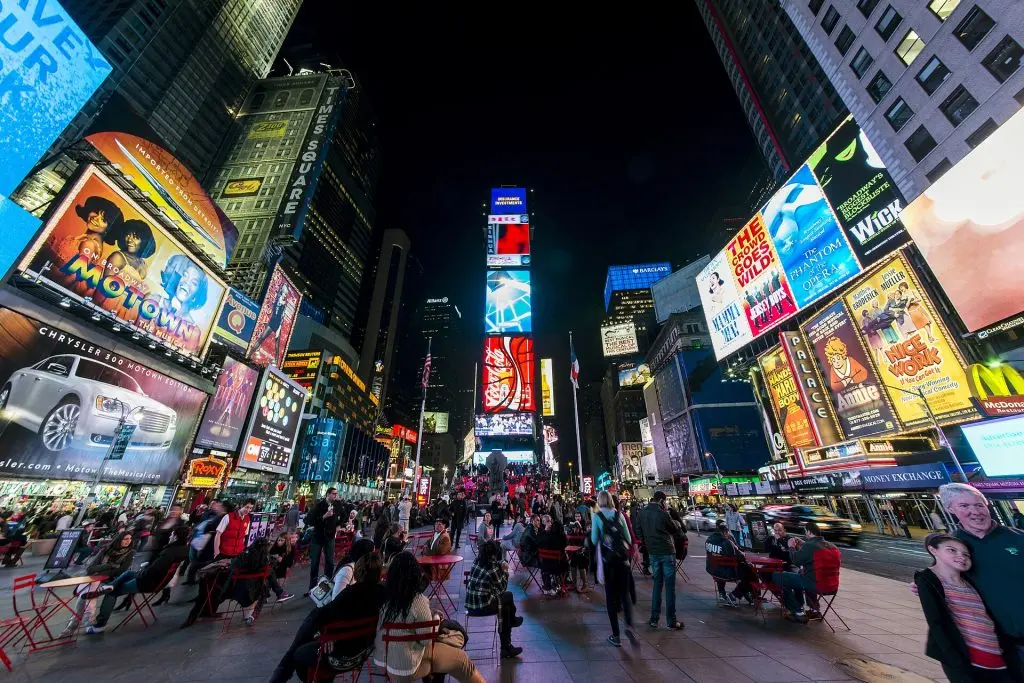 Times Square at night with One Times Square and its illuminated billboards