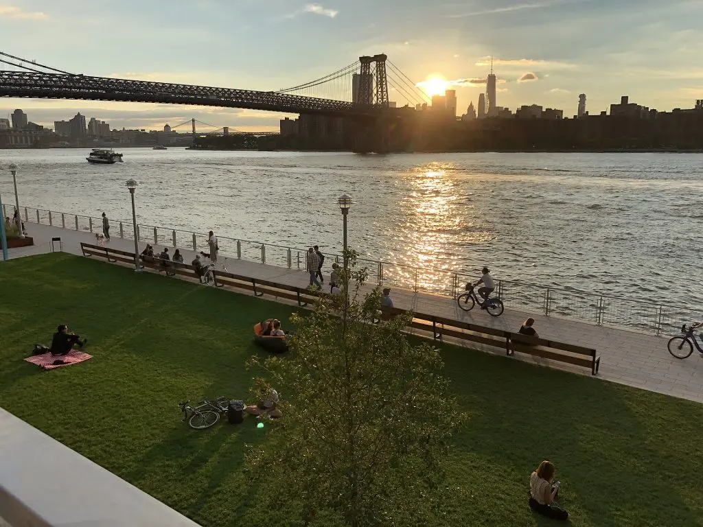 Domino Park waterfront and Williamsburg Bridge at sunset in 2018